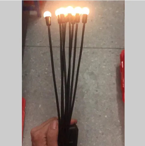 Solar-powered LED firefly garden spike light with multiple heads and a press-in ground plug on grass.
