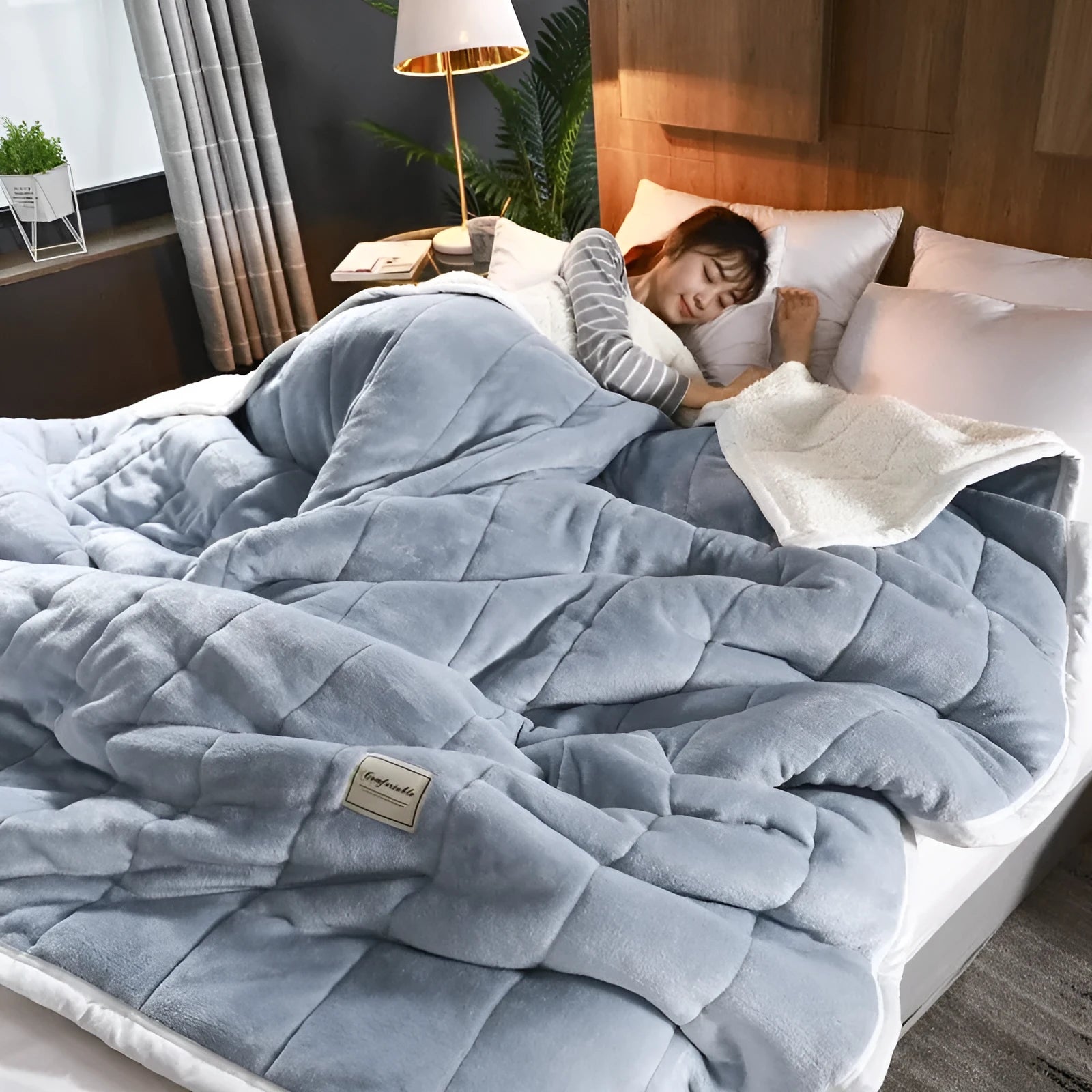 Thick coral fleece winter blanket in a solid colour, shown on a bed, dimensions 150cm by 200cm.