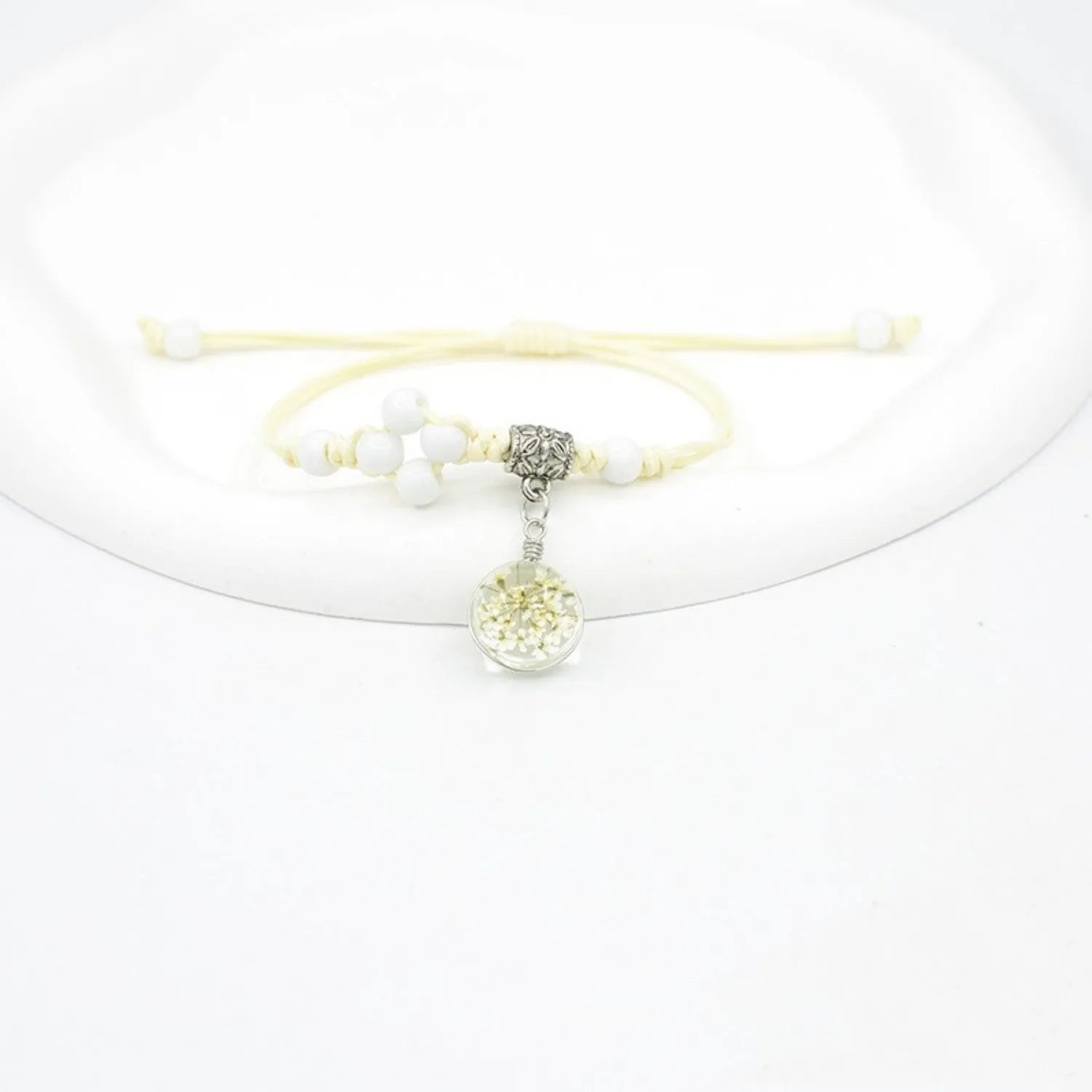 Hand-woven glass bracelet with large beads containing real dried flowers, shown in multiple colour options.