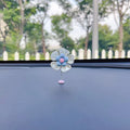 Small colourful plastic swing car decoration on a car dashboard, showing blue, green, pink, purple, and yellow colour options.