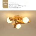 Nordic wooden-style ceiling light with three adjustable heads in a modern living room setting.
