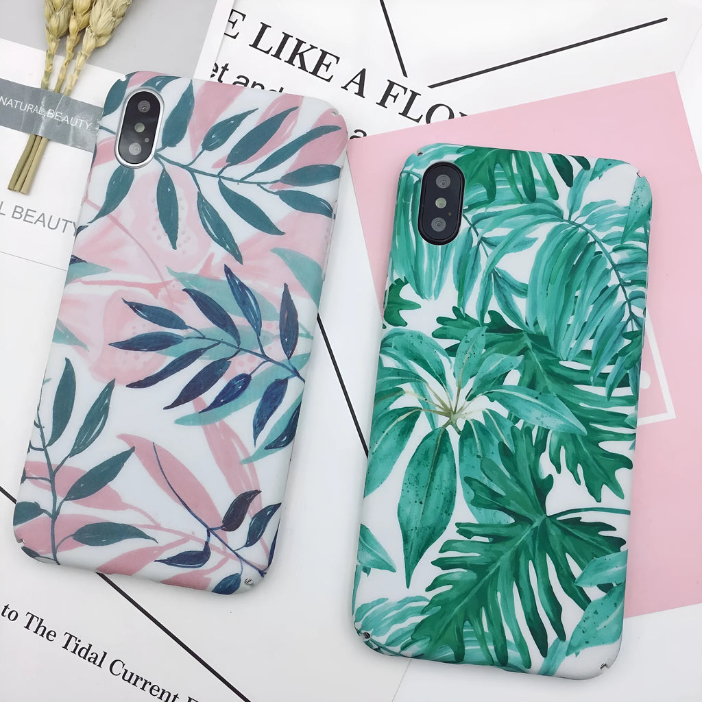 Green and pink painted hard PC back cover cases for smartphones on a table.