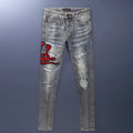 Men's slim fit washed-out denim jeans with hole patches and embroidery on a mid waist.