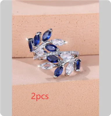 Adjustable copper leaf ring with a central zircon stone on a finger, showing rose gold and platinum colour options.