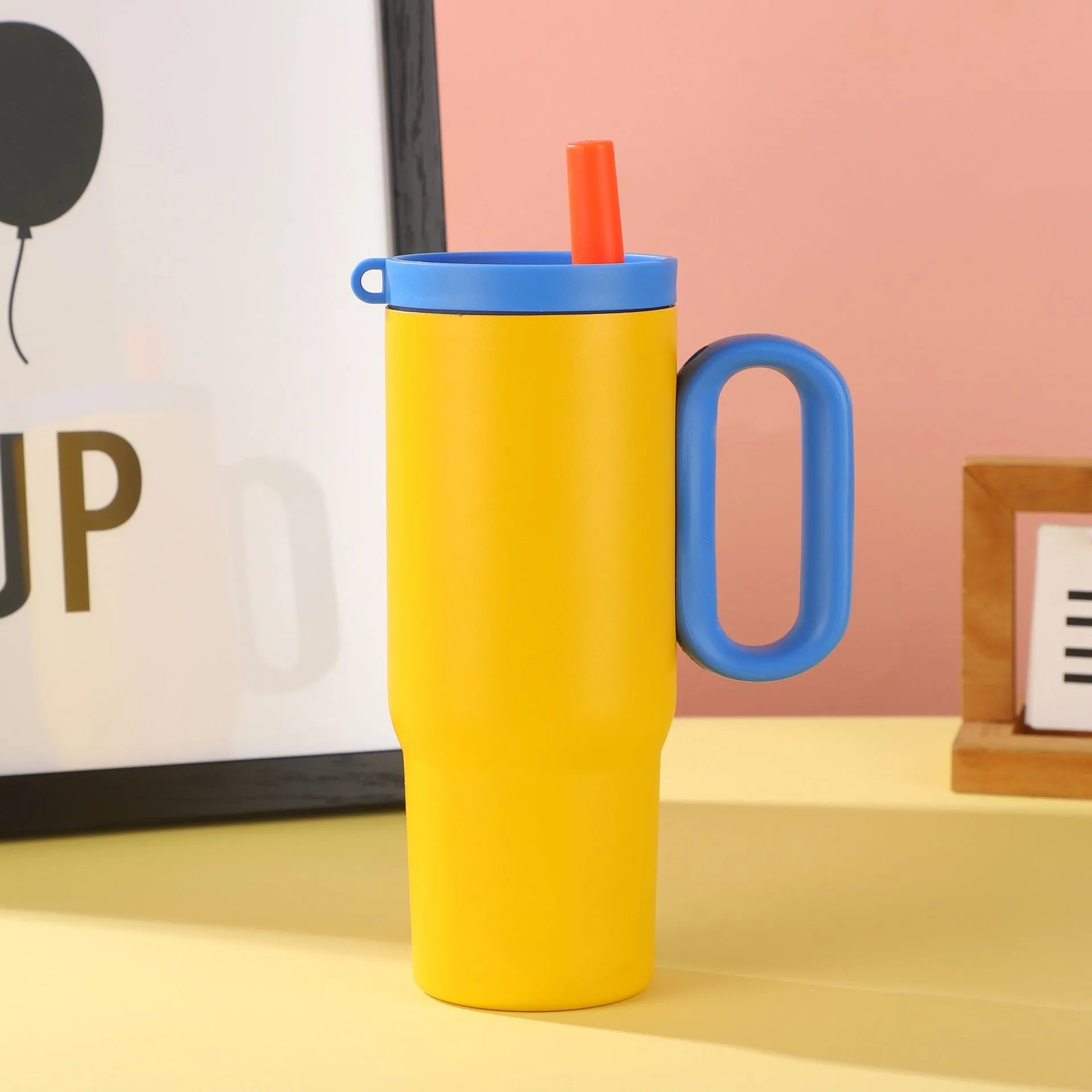 A large insulated portable cup with a handle, shown in multiple colour options.