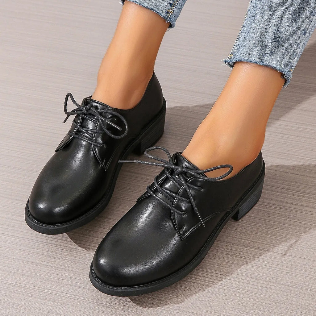 Black women's low-top work shoes with a chunky rubber heel and PU leather upper
