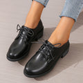 Black women's low-top work shoes with a chunky rubber heel and PU leather upper