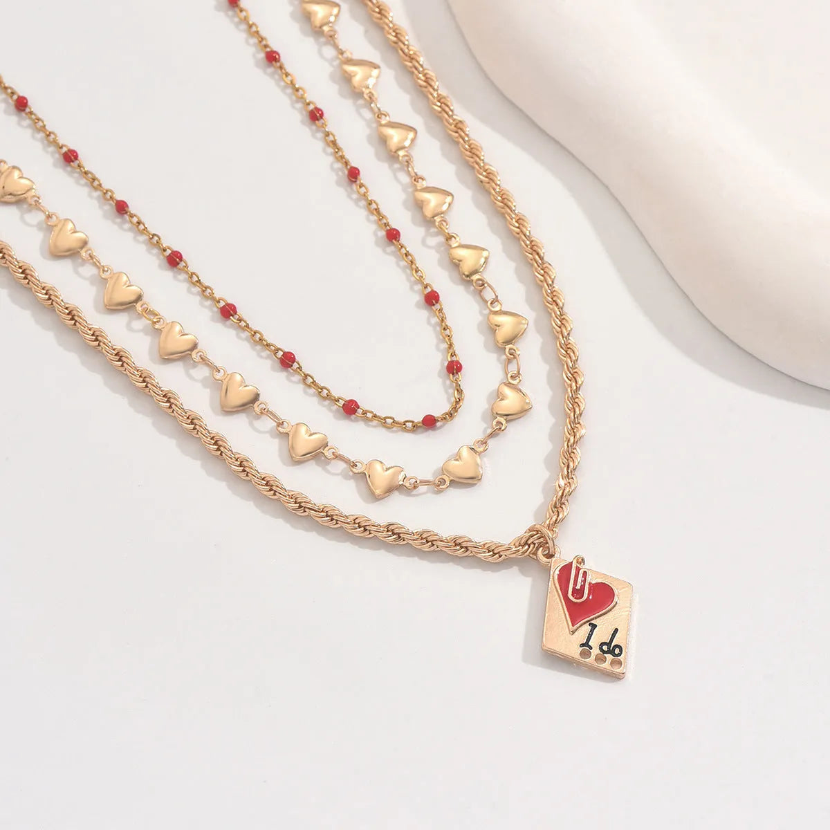Close-up of a zinc alloy heart pendant on an adjustable three-layer clavicle chain necklace.