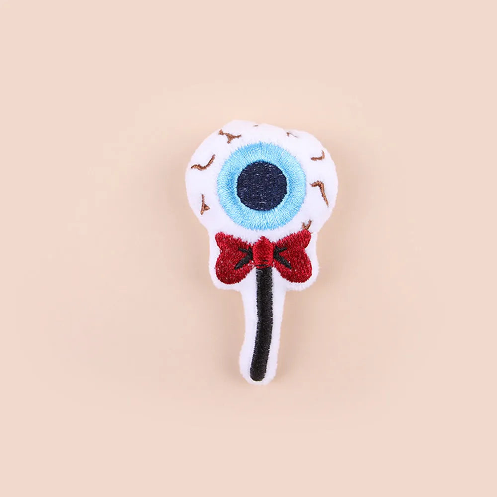 Small cat teaser wand toy with plush candy and skull attachments on string