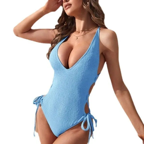 Women's black hollow backless one-piece swimsuit with a central tether strap, sleeveless design.