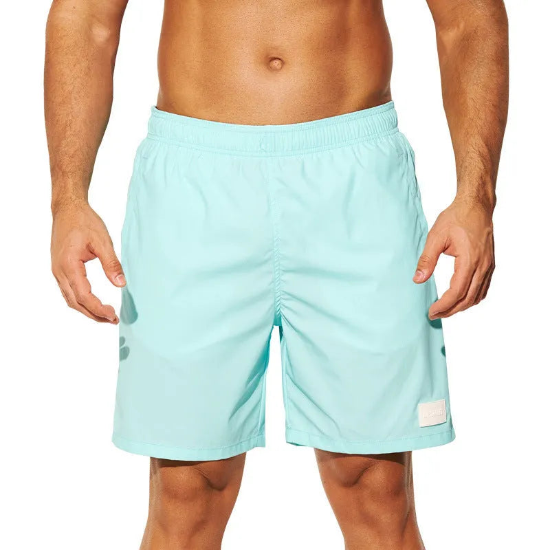 Men's solid colour quick-drying nylon sports shorts on a man, showing straight leg opening.