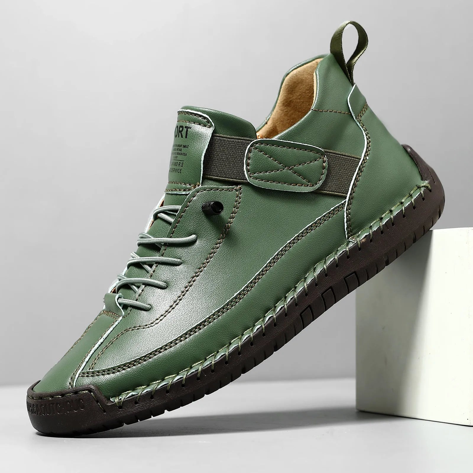 Men's mid-calf Martin boots in khaki with visible tooling stitching and an elastic band across the instep.