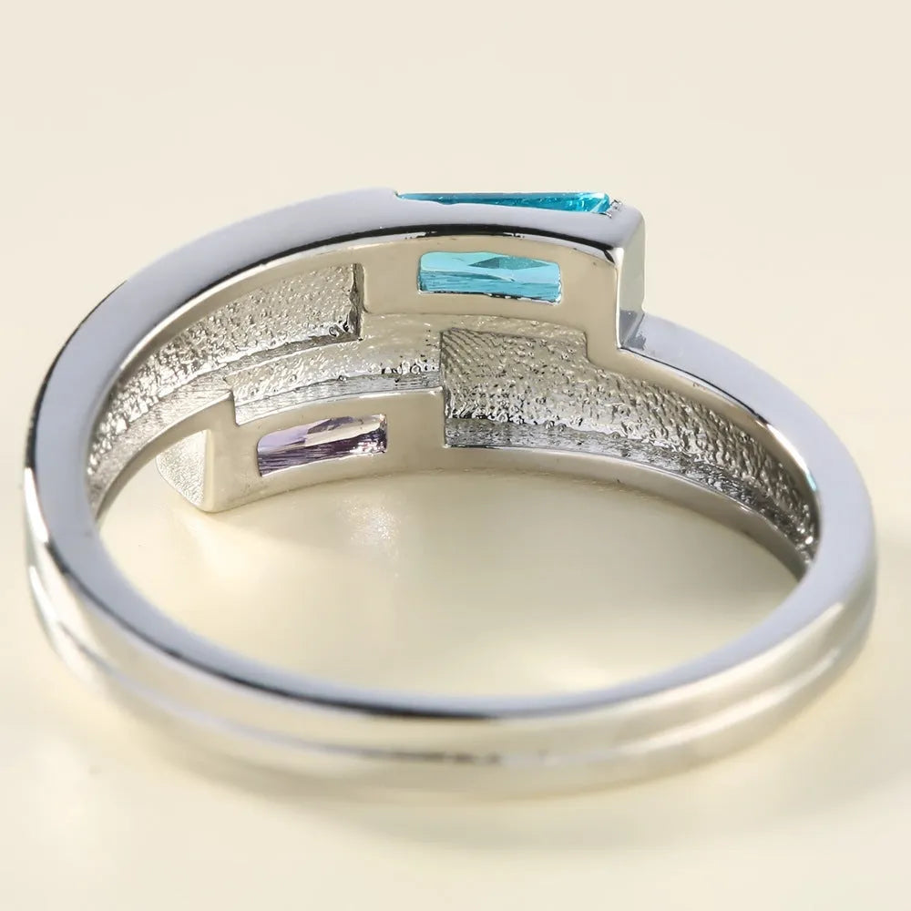 Copper ring with a silver electroplated finish and a central zircon stone, shown on a finger.