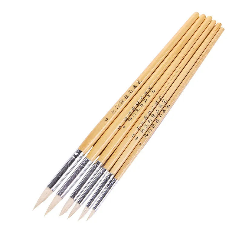Six wooden hook line pen brushes with pointed handles and fine brush nibs arranged as a set