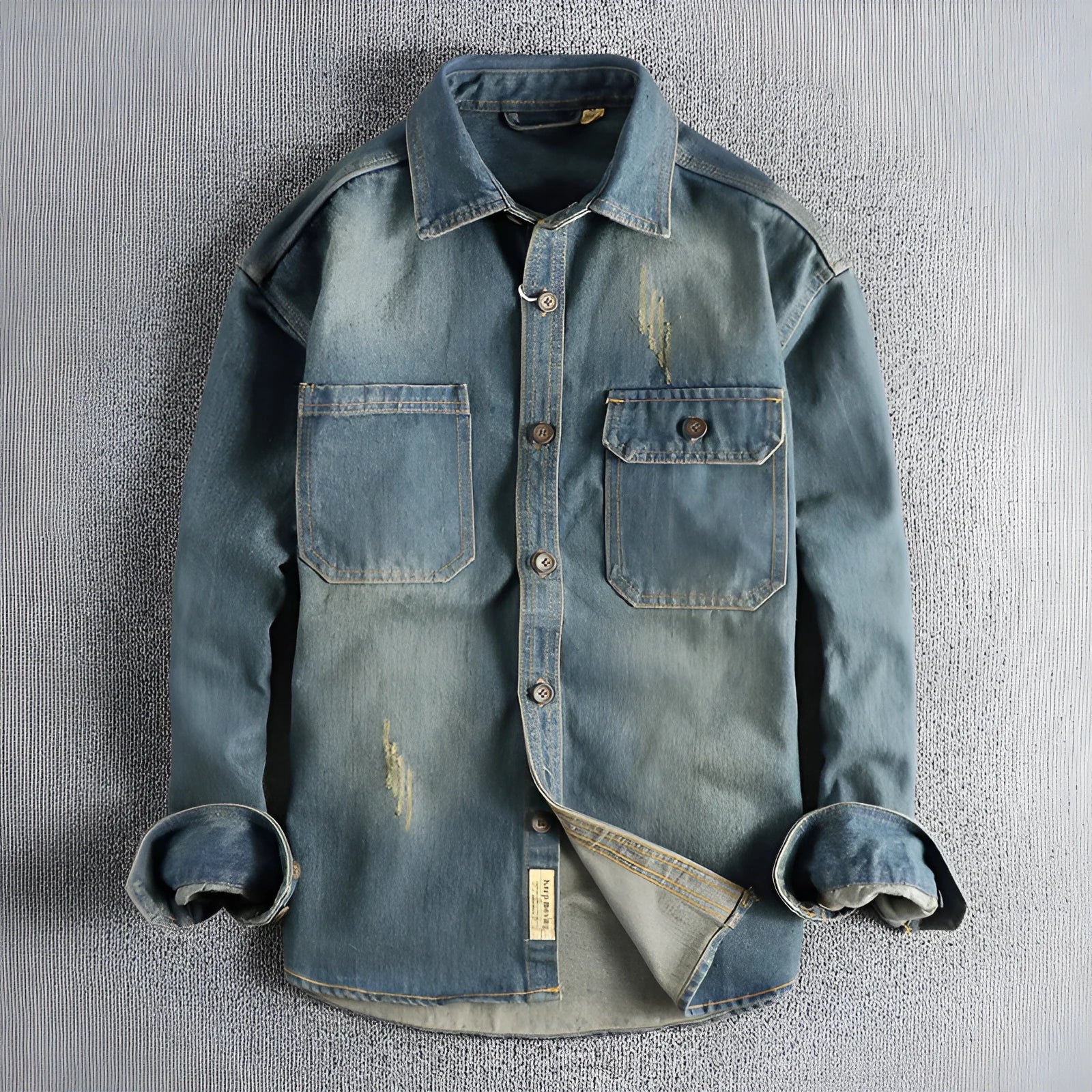 Man wearing a light blue vintage washed denim shirt with a loose fit and long sleeves.