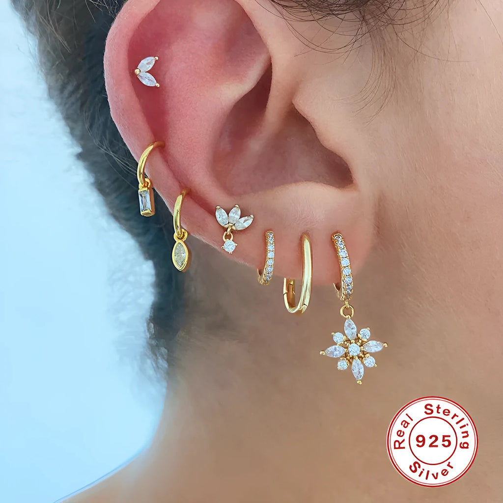 Pair of S925 sterling silver snowflake pendant earrings with gemstone inlay on a white background