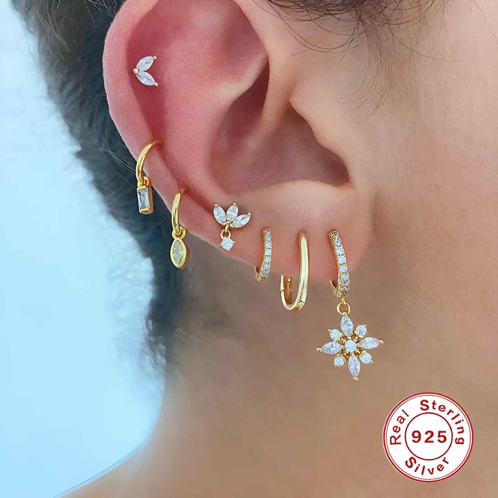 Pair of S925 sterling silver snowflake pendant earrings with gemstone inlay on a white background