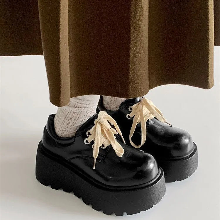 Matte black women's lace-up shoes with a chunky muffin heel and thick rubber sole