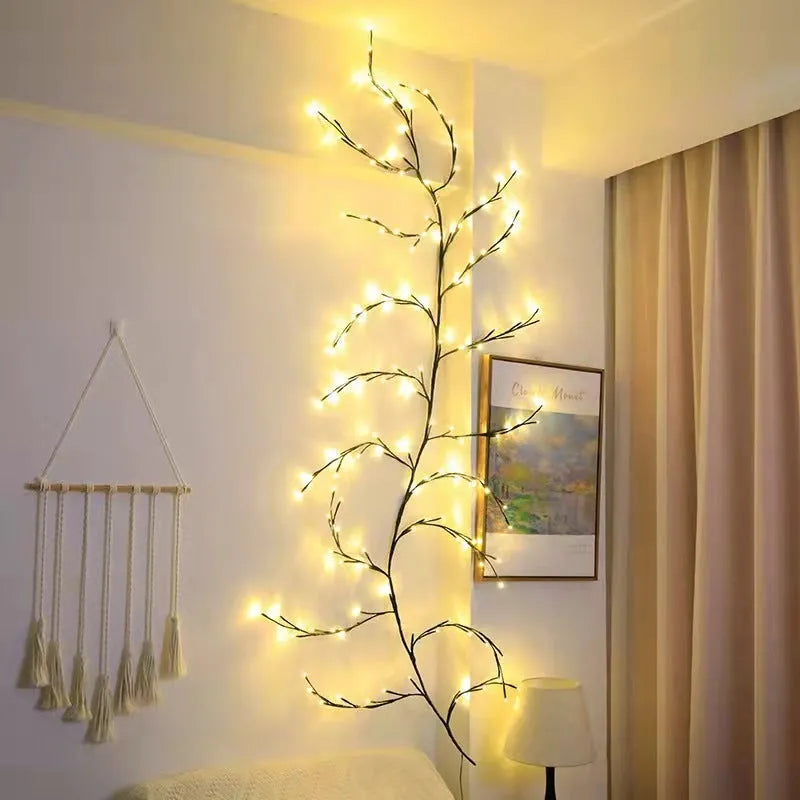 Flexible plastic LED willow vine garland with warm white lights bent into a decorative shape on a wall.