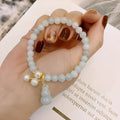 Traditional Chinese style jade bracelet with raised gourd design and pearl accents on green stone