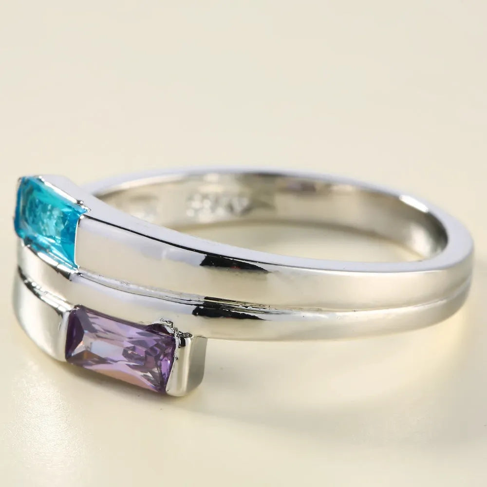 Copper ring with a silver electroplated finish and a central zircon stone, shown on a finger.