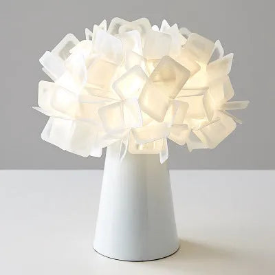 Nordic style decorative table lamp in a choice of colours including black, blue, and orange on a wooden surface.