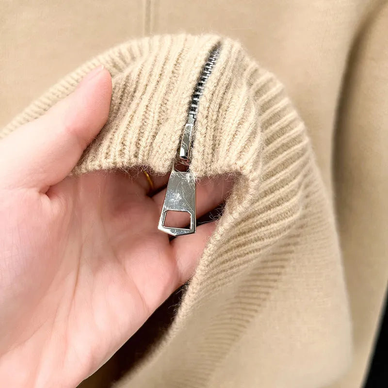 Man wearing a thick grey stand collar knitted cardigan with a zipper front.