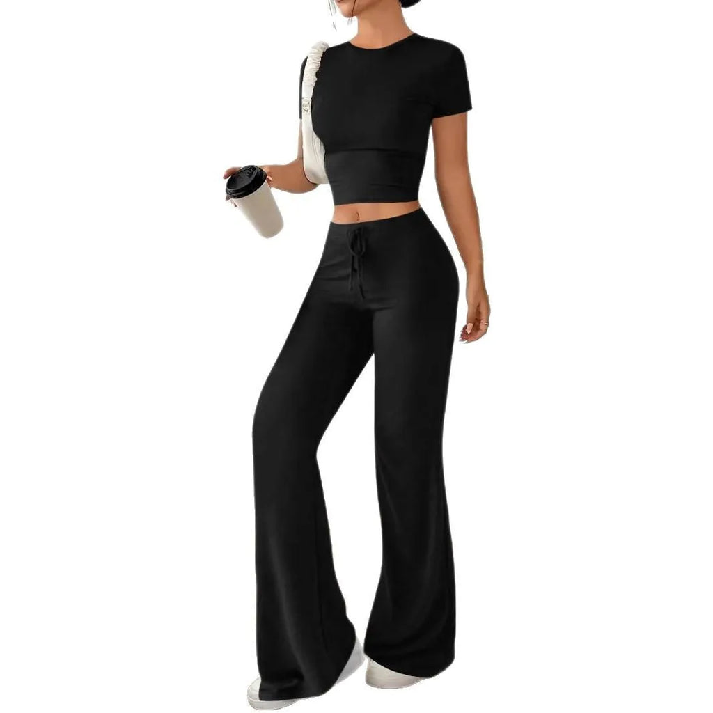 Black high-waist polyester trousers and matching short-sleeve t-shirt laid flat as a two-piece suit set.