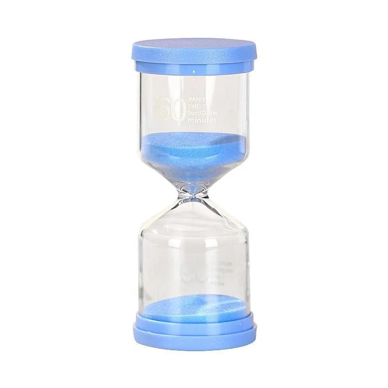 Handmade glass sand timer in blue colour showing sand flowing, on a wooden desk.