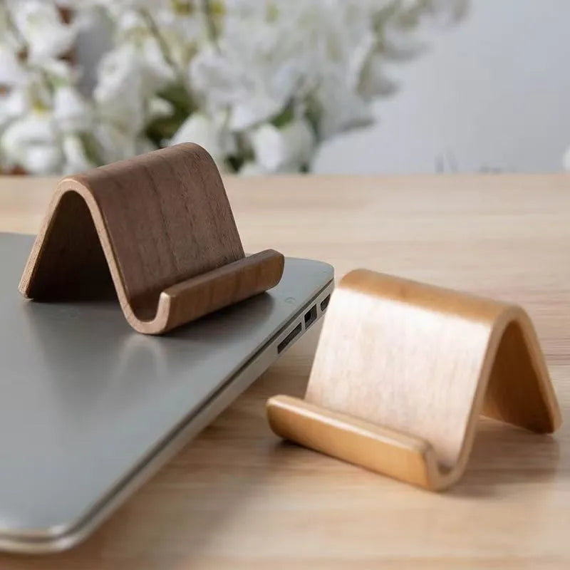 Walnut wooden mobile phone bracket on a desk, with a smartphone placed in the stand