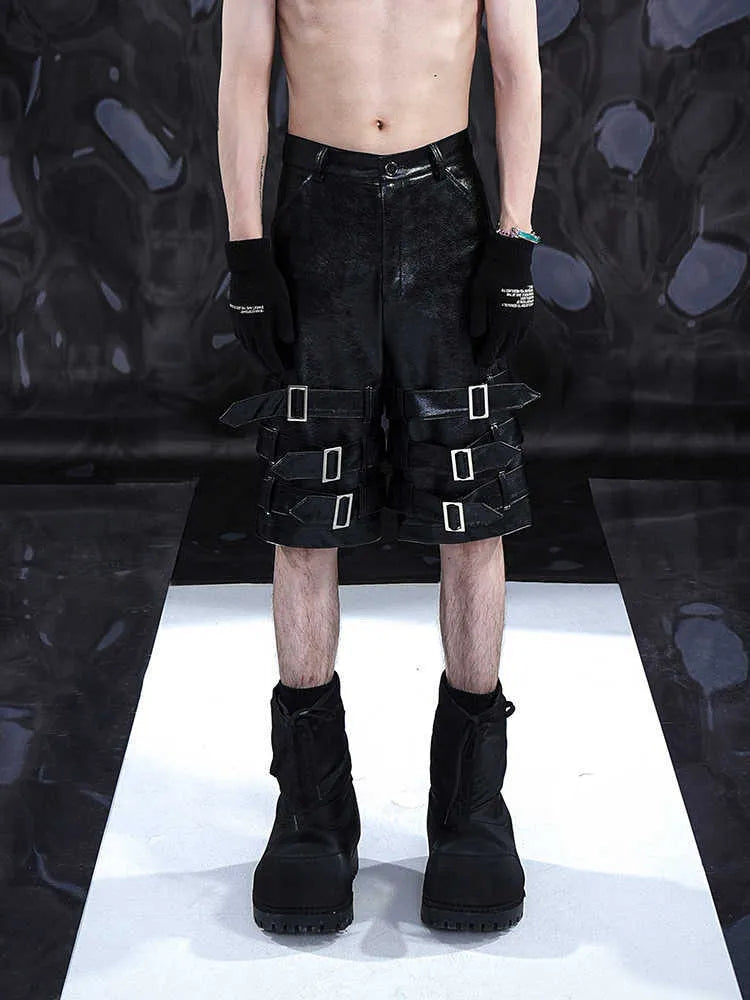 Black men's leather-look casual cropped shorts with ring details on a low-rise waist.