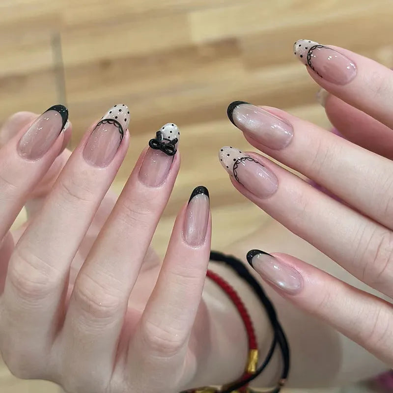 Set of medium-length coffin-shaped false nails with French manicure glitter tips and rhinestone decorations.