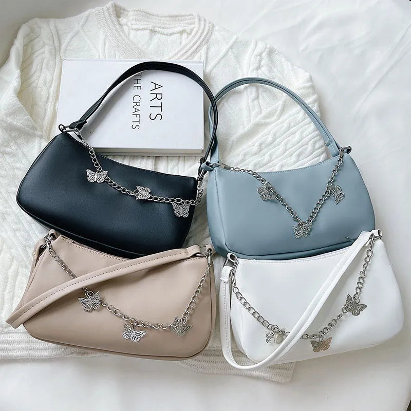 Women's black PU leather butterfly chain underarm bag showing crossbody wear with retro styling