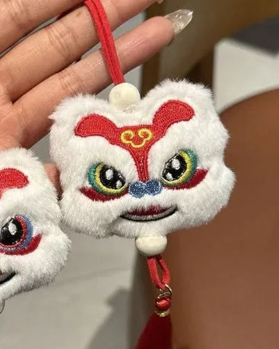 Handmade blue and yellow plush Chinese lion keychain with star stone on a key ring.