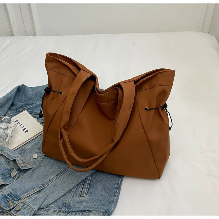 Soft foldable Oxford cloth shoulder tote bag in a street style, shown in various colours.