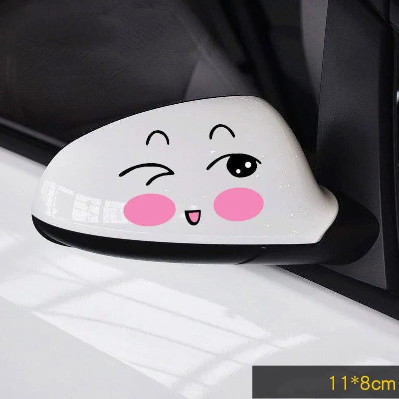 Pair of reflective cartoon car stickers with cute eyes on a car rearview mirror.