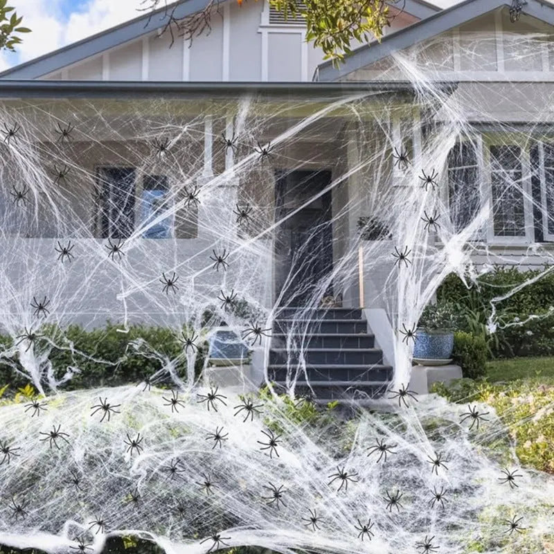 Halloween cotton spider web decoration pack with white plastic spiders draped over a branch