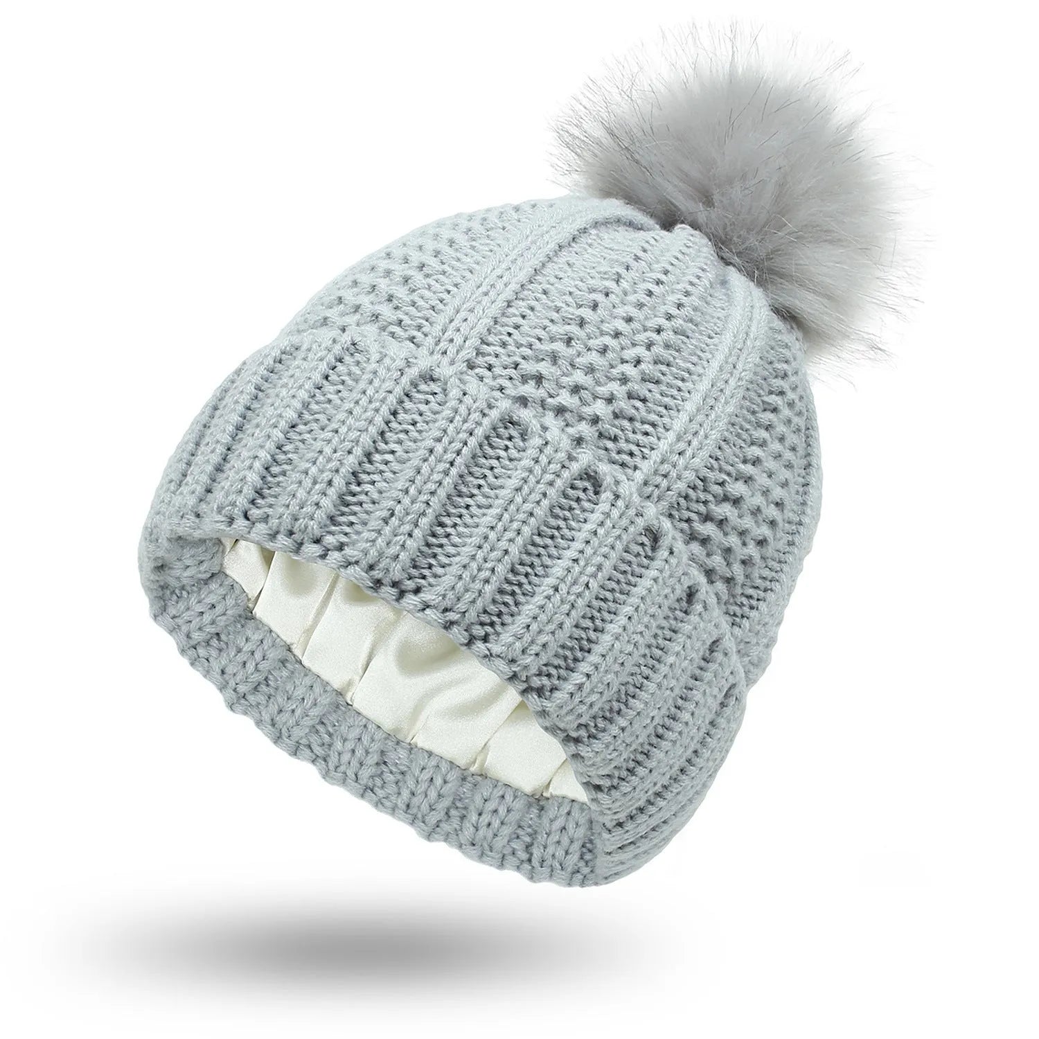 Women's knitted beanie hat with faux fur pom pom and satin lining in multiple colour options.
