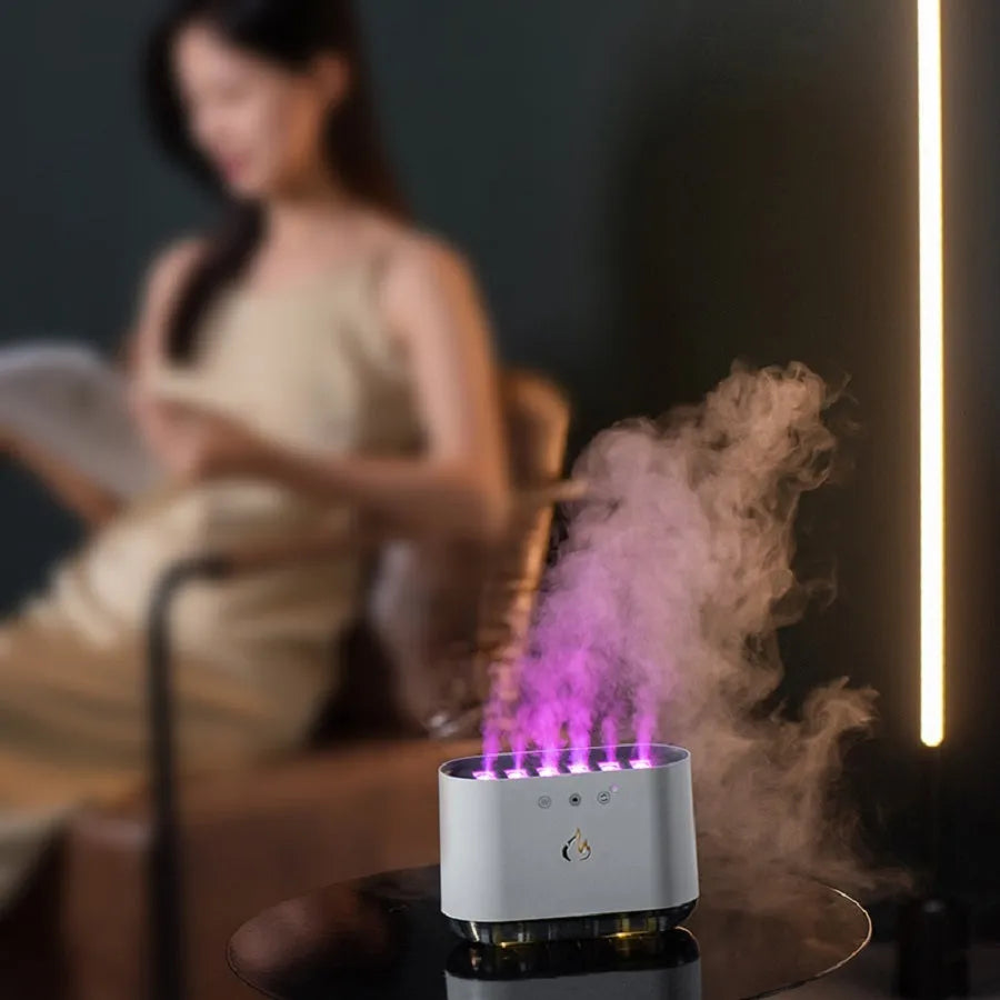 White cylindrical humidifier with colourful LED base and mist rising from the top.