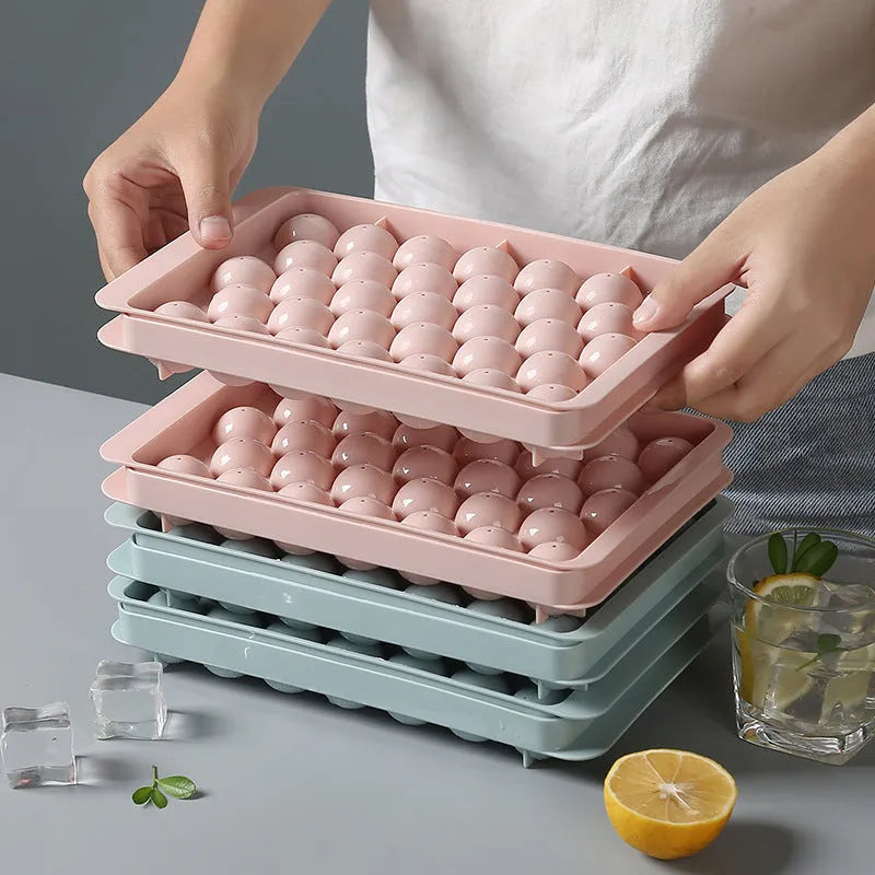 Sky blue 3D round ice ball mould tray with 18 grids next to a pink tray with 33 grids.