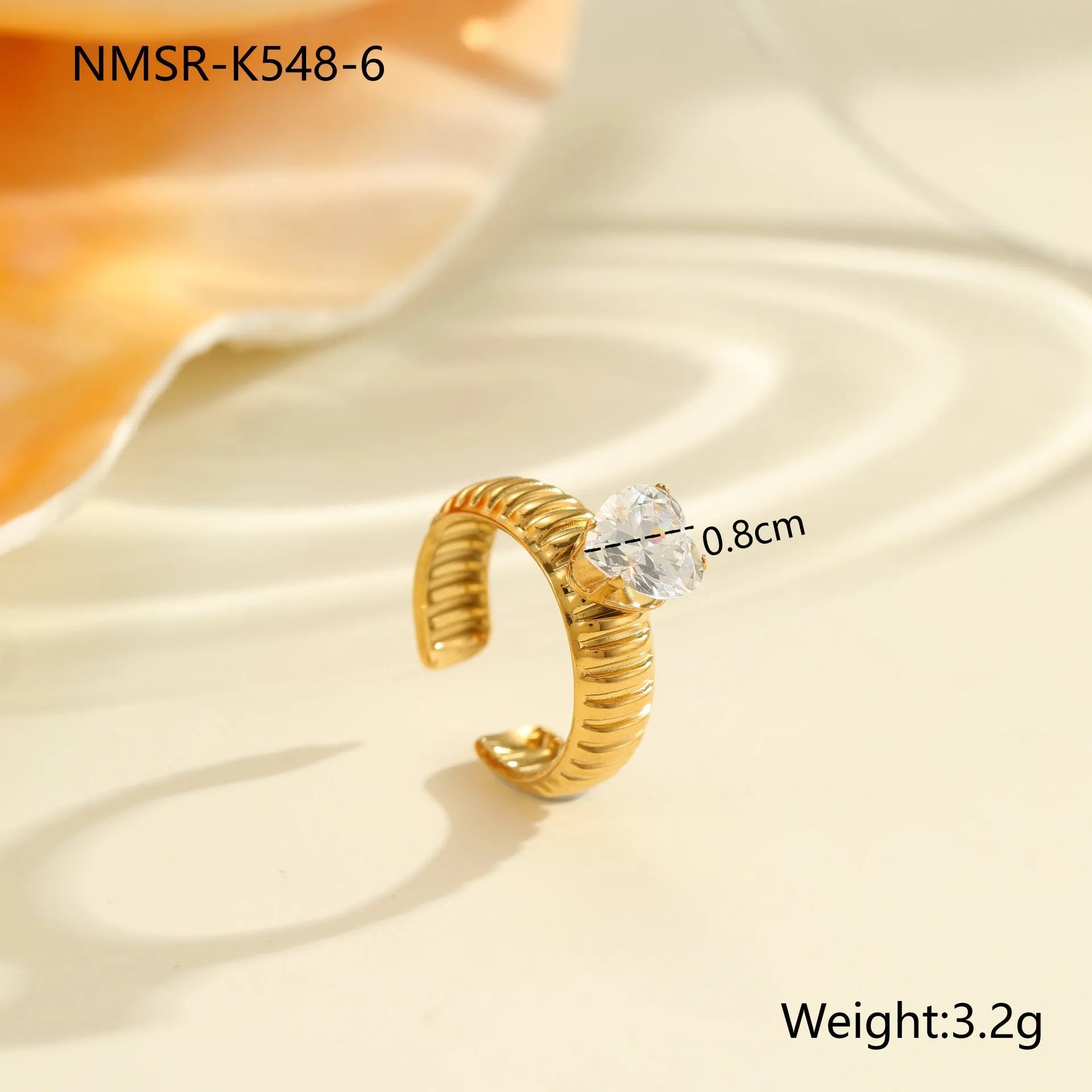 Gold electroplated adjustable ring with geometric zircon design on a stainless steel band.