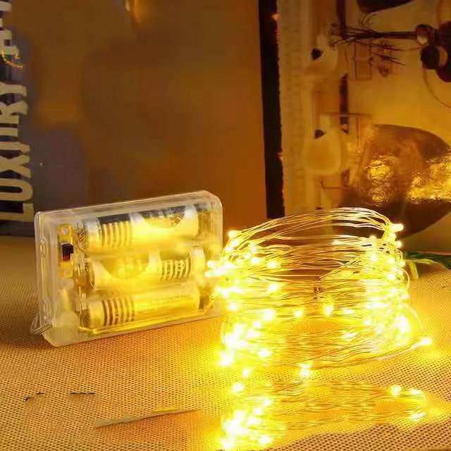 Flexible copper wire LED string lights bent into a spiral shape, showing 120 small bulbs and a white control box.