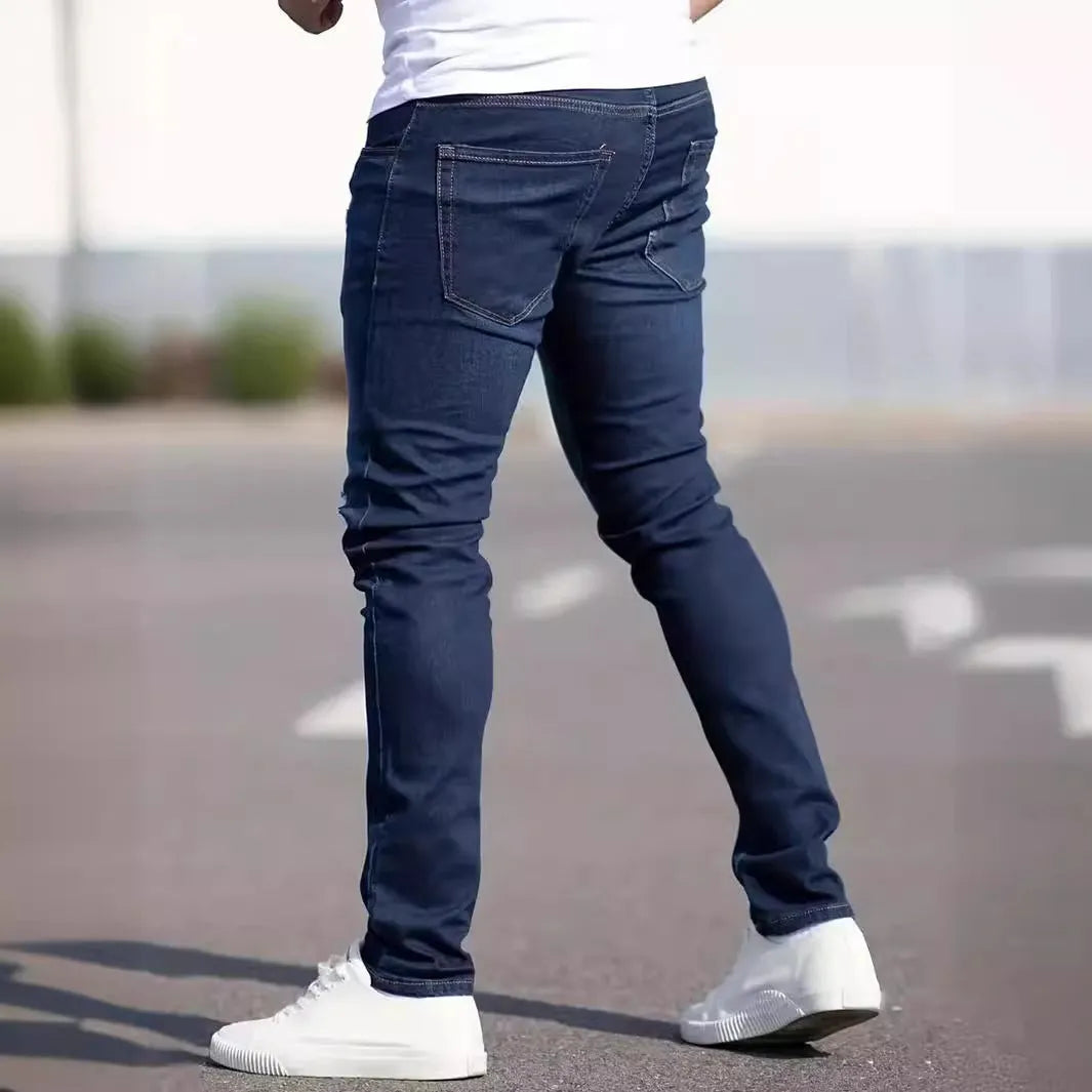 Dark blue men's slim-fit cotton jeans with a skinny leg opening on a plain background.