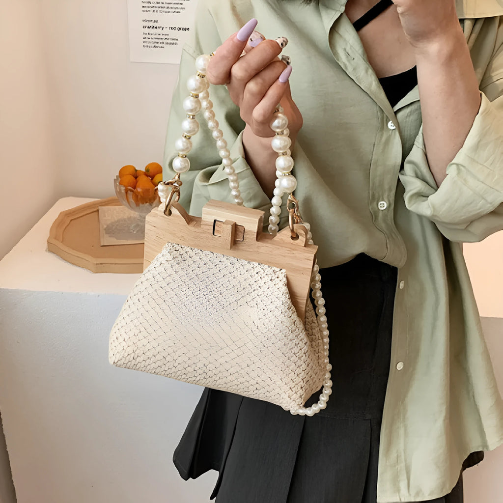 Women's woven straw shoulder bag with pearl chain detail showing horizontal square shape and multiple internal pockets