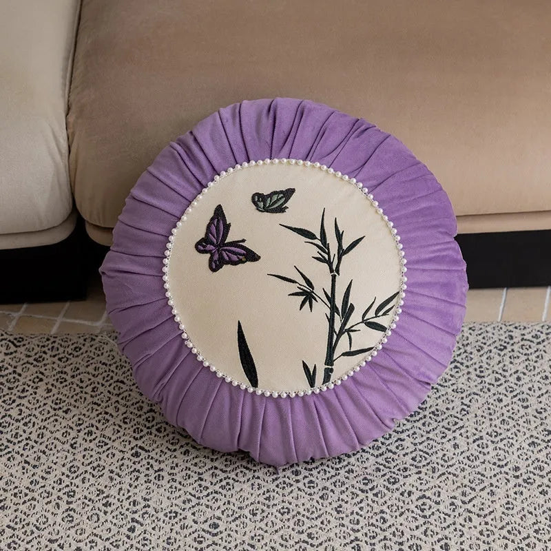 Square beige cushion with colourful embroidered butterfly and Chinese floral pattern.