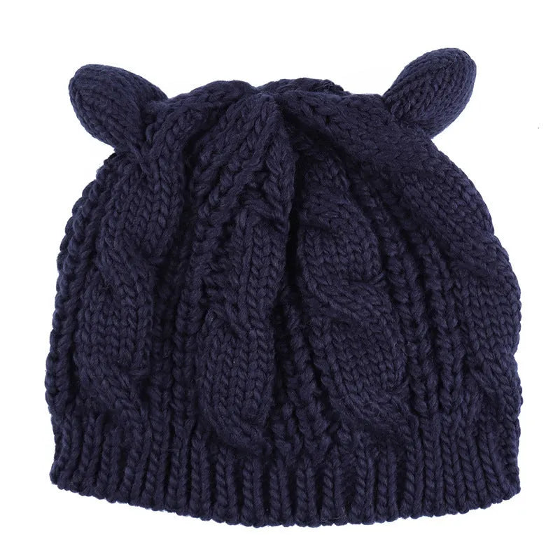 Hand knitted red wool beanie with 3D cat ears on a white background