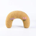 Blue and yellow question mark shaped cat bed with a U-shaped pillow for neck support on a wooden floor.