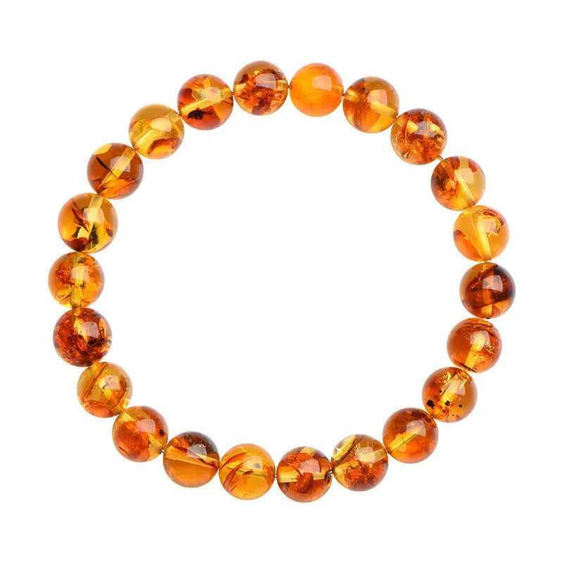 A geometric-bead amber bracelet with natural yellow piebald colouration on a wrist.