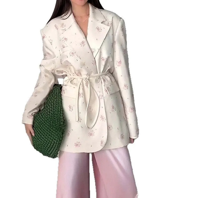A printed suit jacket with a lace-up collar detail and waist-tightening feature on a mannequin.
