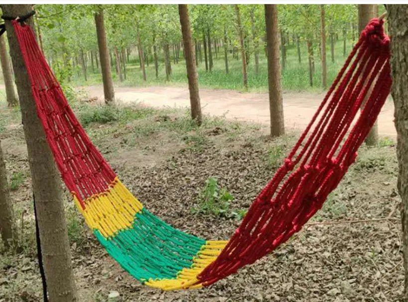 Outdoor bold style nylon rope mesh hammock shown in a garden setting